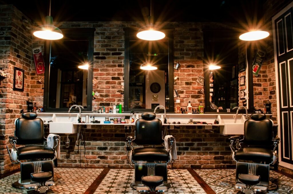 Black leather barber chair against a brick wall in a barbershop