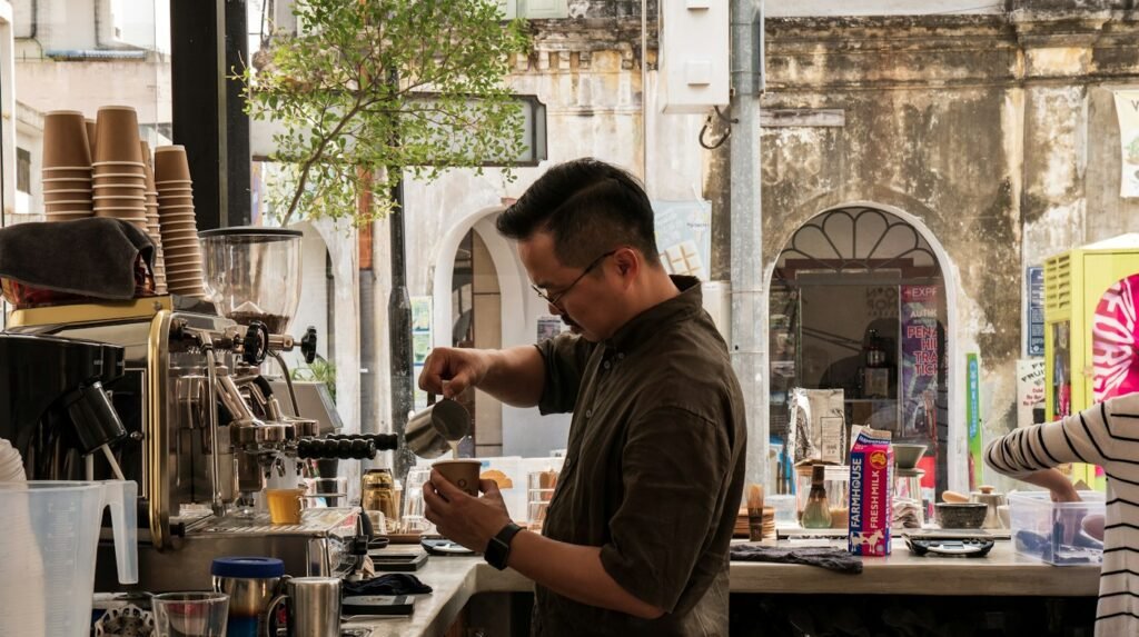 Barista pouring steamed milk into a takeaway coffee cup