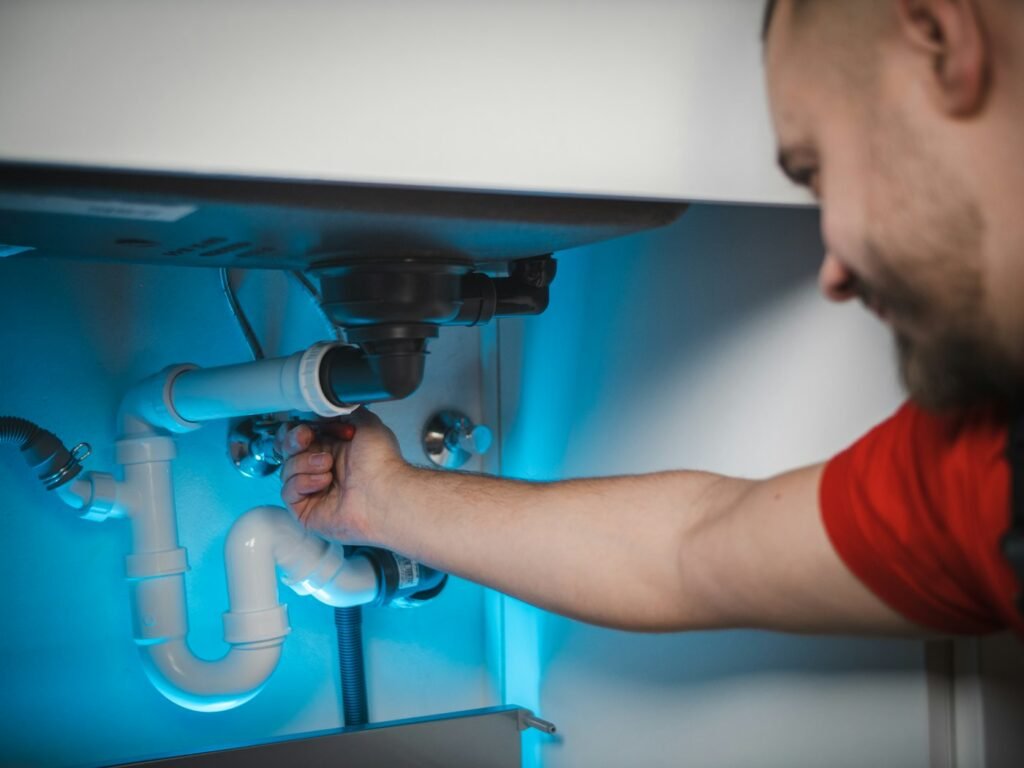Plumber repairing pipework inside a wall