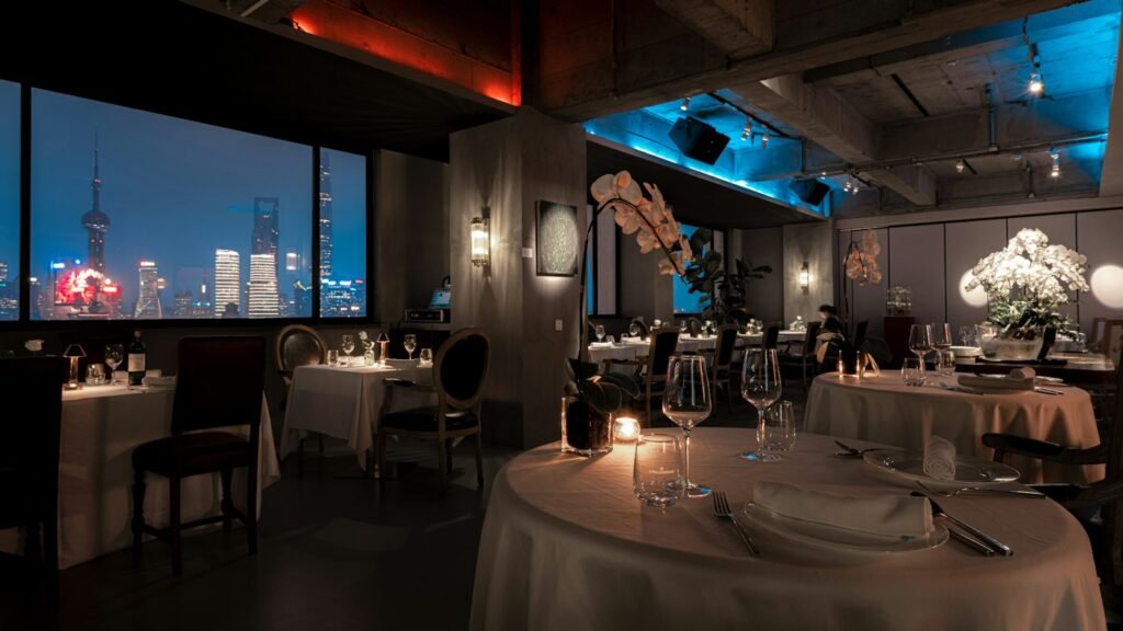 Dimly lit restaurant dining room with a city view